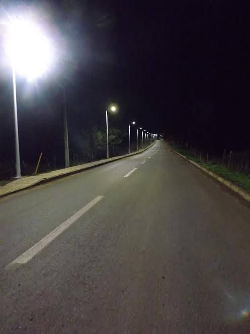 Camino recto de noche con postes encendidos