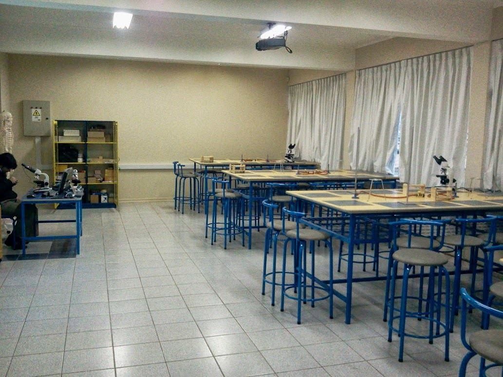 Laboratorio amplio con taburetes azules y mesones