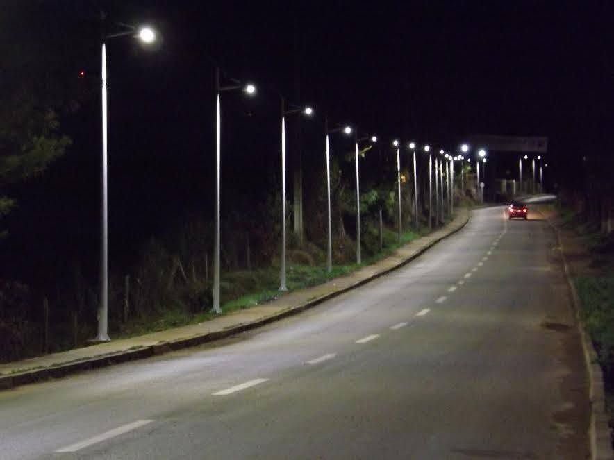 Camino curvo de noche iluminado por una fila de postes